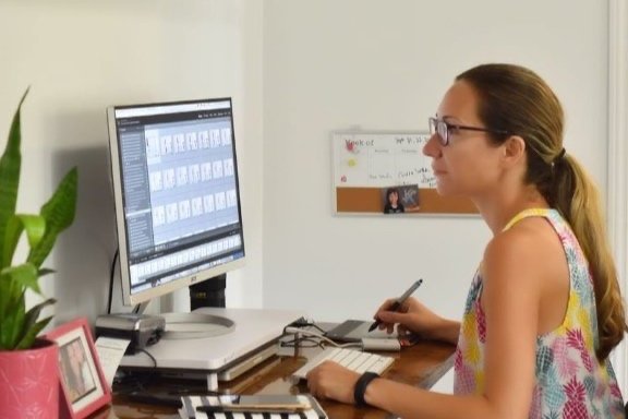 Woman working on a computer at her desk, editing photos - how to take personal branding photos for Instagram
