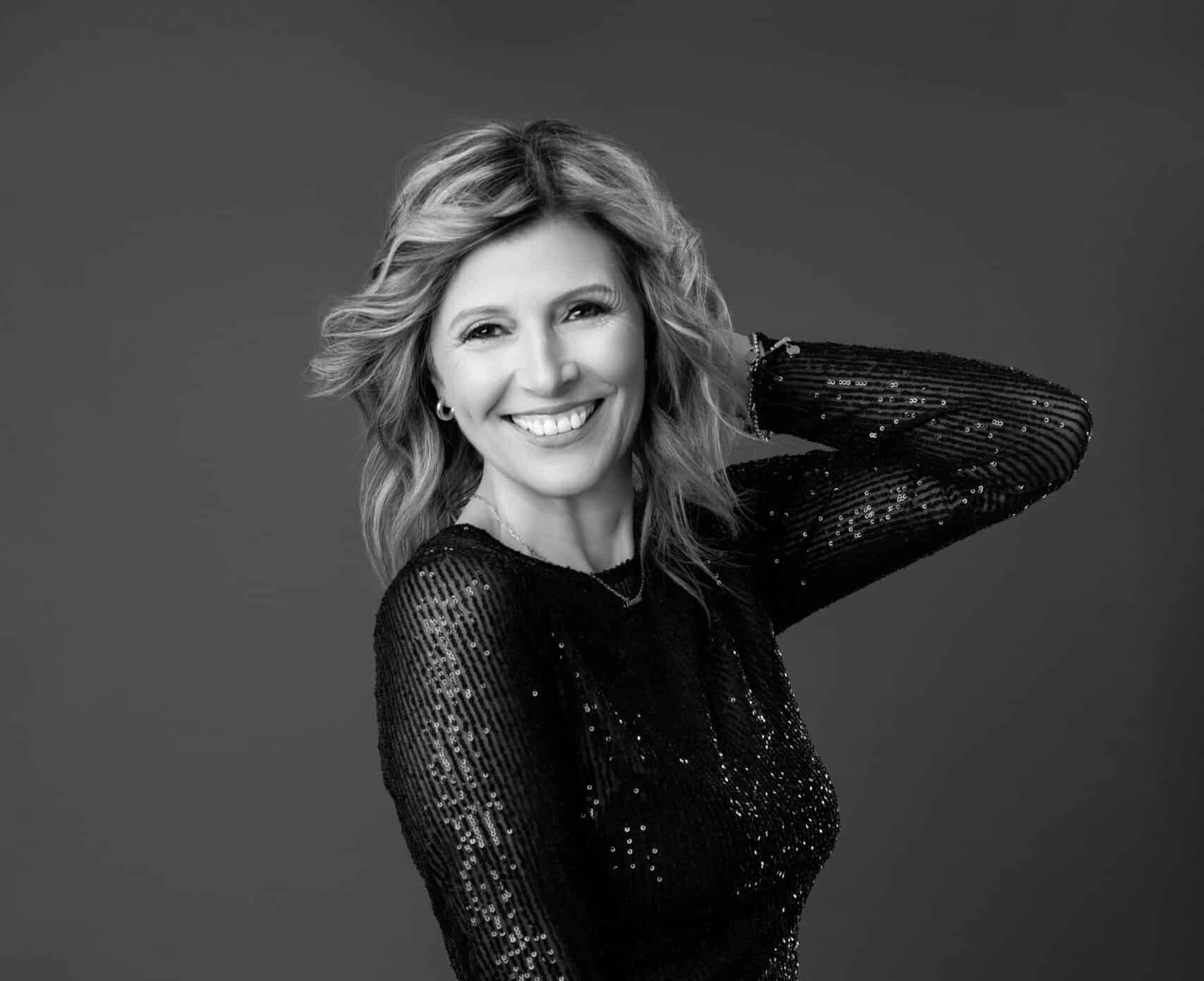 Black and white studio portrait of a smiling woman in a sequin top, joyful confident pose — Ellahrika Photography, Milton, Ontario