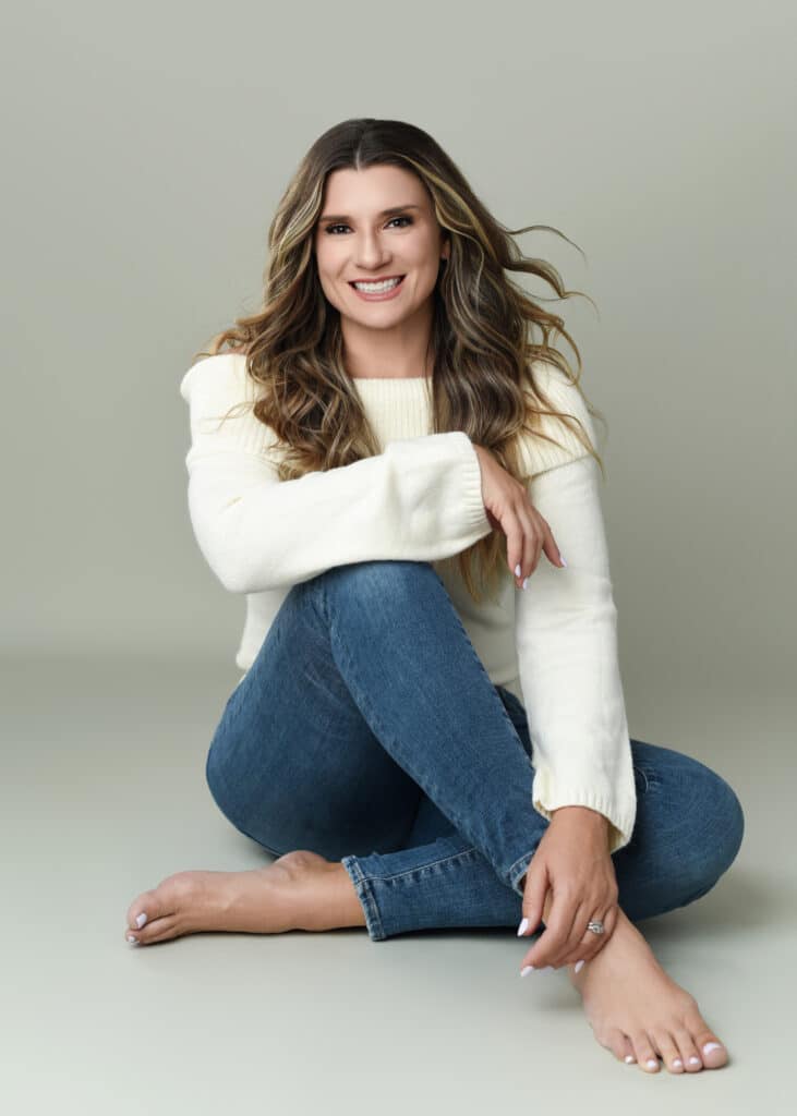 Woman in cream sweater and jeans sitting barefoot on floor, relaxed smiling pose — Ellahrika Photography, Milton, Ontario